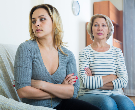 Senior lady and young woman having domestic quarrel indoorsの写真素材