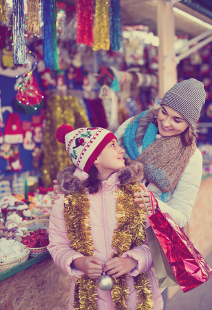 Satisfied pleasant  female customers staring at counter of Christmas market. Focus on womanの写真素材