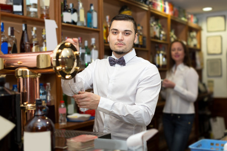 portrait of happy barman pouring beverages and smilingの写真素材