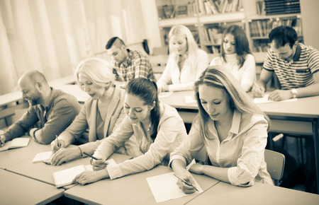 Adult professionals taking notes at training session for employeesの写真素材