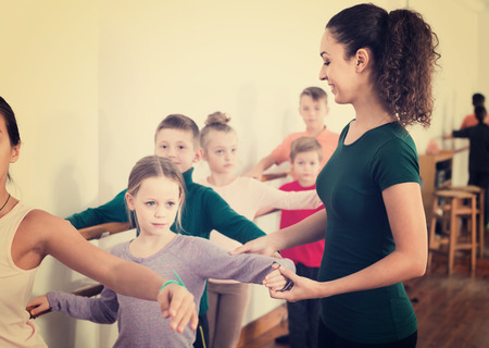 Group of smiling spanish children practicing at the ballet barreの写真素材