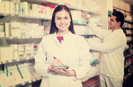 Two happy friendly pharmacists working in modern farmacyの写真素材