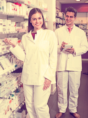 Portrait of two positive friendly  pharmacists working in modern pharmacyの写真素材