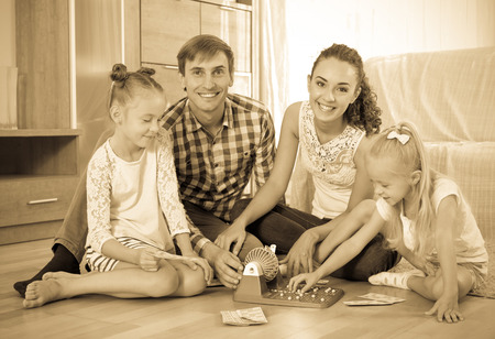 Llittle girls with young smiling parents trying chances at lotto gameの写真素材