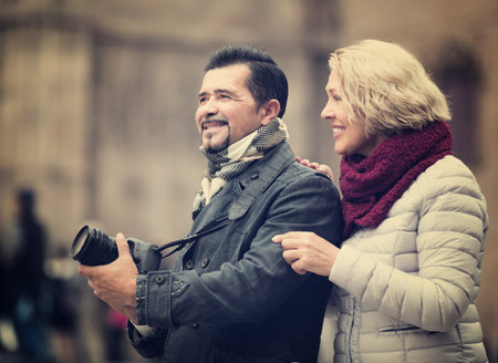Senior couple of travellers sightseeing and making photoes around
