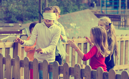 Cheerful children playing at Blind man bluff outdoorsの写真素材