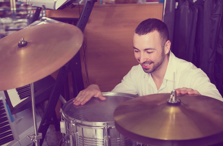 Male buyer choosing drums and accessories in music shopの写真素材