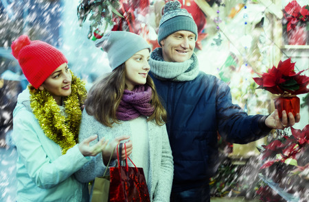 smiling european family of three with teenage girl choosing  floral decorations  at market. Shallow depth of focusのeditorial素材