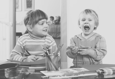 Two children  with pencils in home interiorの写真素材