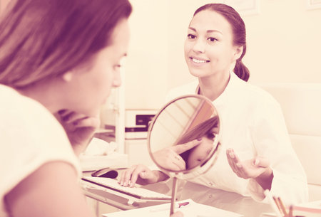 Smiling visitor listening  beautician in aesthetic medicine centerの写真素材