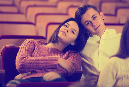 Loving young couple attending movie night at date in cinemaの写真素材