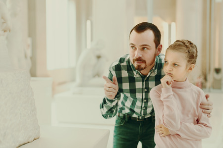 Positive father and small girl  looking ancient statues in museumの写真素材