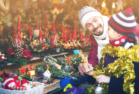 Smiling father showing daughter souvenirs which they will buy for Christmasの写真素材