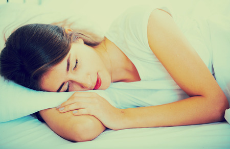 Relaxed girl in pyjamas taking nap during siesta indoorsの写真素材