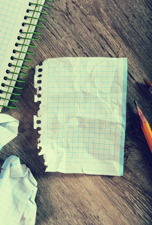 Notepad with writing utensils lying in disarrayの写真素材