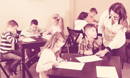 cheerful american  children of elementary age having class of art