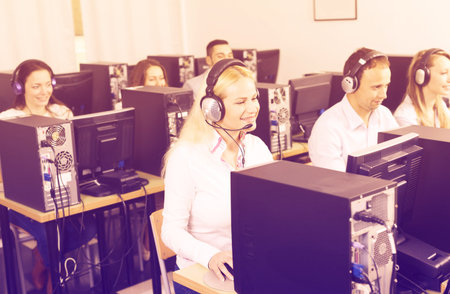Working process of call center team at office. Focus on the blond woman