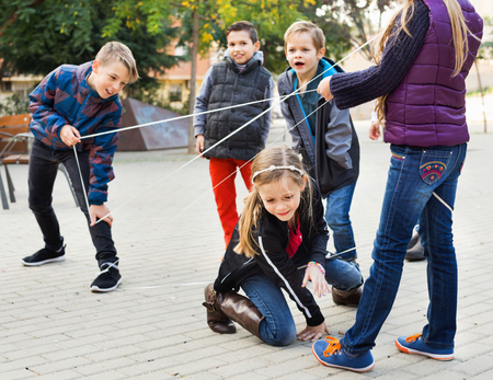 Children games. Smiling happy  girl goes through the tangled ropeの写真素材