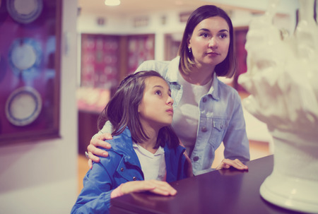 Pretty mother and daughter exploring medieval expositions in museumの写真素材