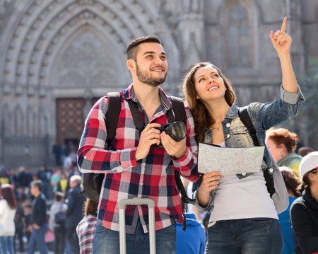 Happy tourists man and his girlfriend enjoying excursion and taking picturesの写真素材