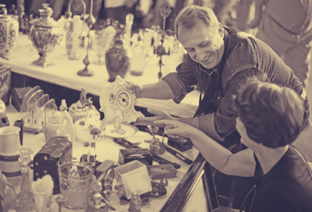 Elderly man and woman 55-65 years old consider things in flea marketの写真素材