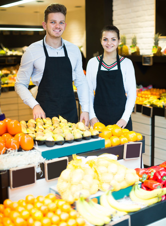Happy shopping assistants demonstrating assortment of grocery shopの写真素材