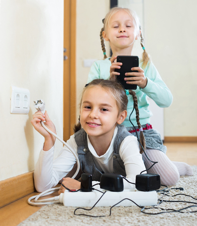 Careless american children playing with sockets and electricity indoorsの写真素材