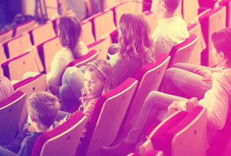 Little girl is distracted from screen during movie in cinemaの写真素材