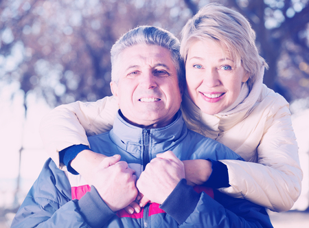 Happy mature married couple embracing on sunny day in parkの写真素材