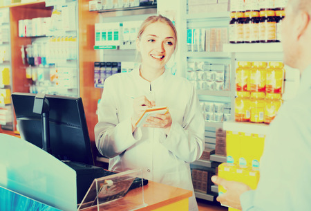 Female pharmacist counseling customer about drugs usage in modern farmacy interiorの写真素材