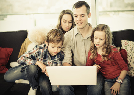 Glad parents and children happy to watch movie together at home. Focus on the boyの写真素材