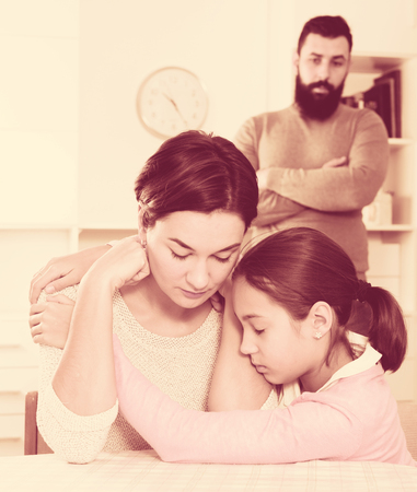 Young father correcting his wife and child for disobedience at homeの写真素材