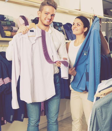 Young couple purchasing shirt, jacket and tie at shopの写真素材
