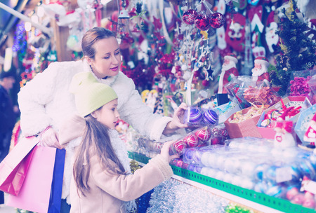 Mother with little girl in Christmas market. Focus on girlの写真素材
