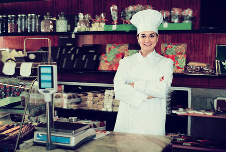 Adult female assistant demonstrating assortment of confectioneryの写真素材