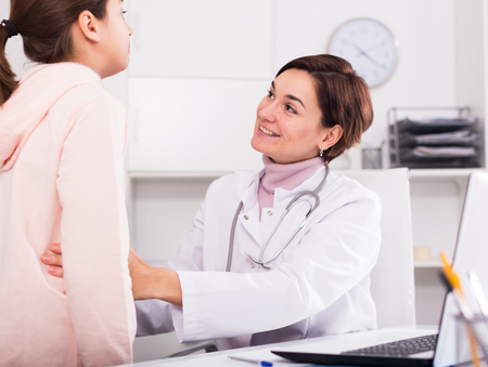 Teenage girl has come to hospital to therapist for survey of condition of healthの写真素材