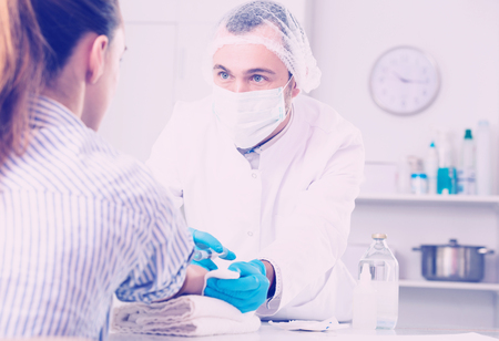 Male nurse using syringe to make injection to patient in hospitalの写真素材