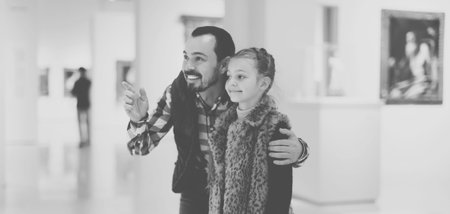 Young father and daughter exploring paintings exhibitions
