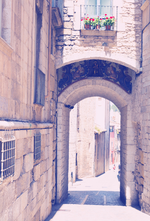 Arch over old narrow street of european city.  Girona, Spainの写真素材