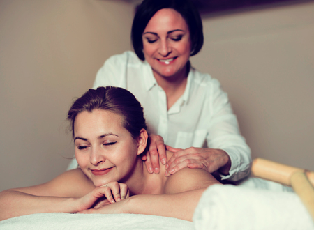 Young woman likes procedure of massage and waiting for use bamboo sticks for massageの写真素材