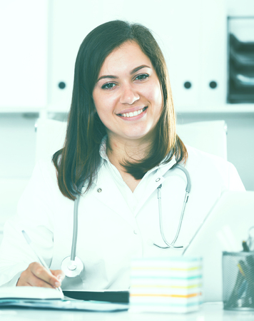 Young female doctor ready to receive clients in her officeの写真素材