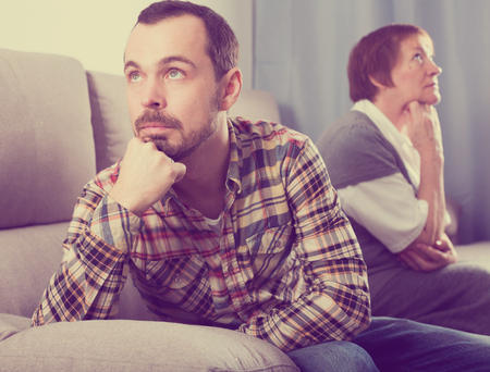 Mature mother having disagreement with adult son at homeの写真素材