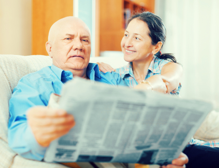 Portrait of a smiling elderly people with newspaperの写真素材