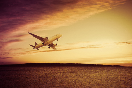 Plane flying in the sky above water with great speedの写真素材