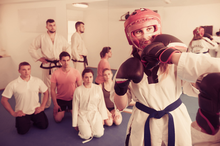 Young woman training new taekwondo holds with adults during classの写真素材
