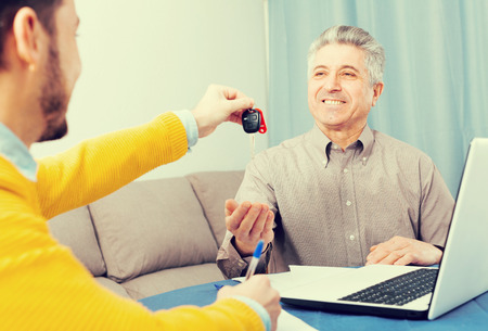 Adult man and manager signed contract car hire at home and hand over keysの写真素材