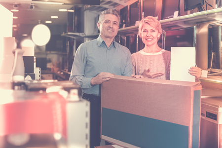 Pretty mature married couple are happy buying on credit household appliances for homeの写真素材