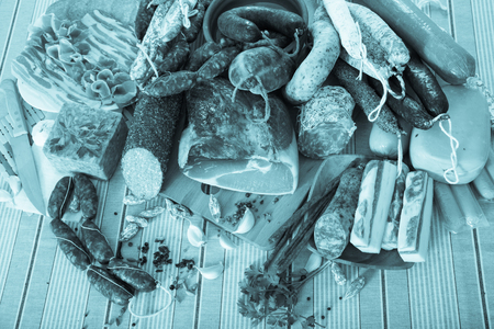 Variety of meats, sausages and mince with herbs on tableの写真素材