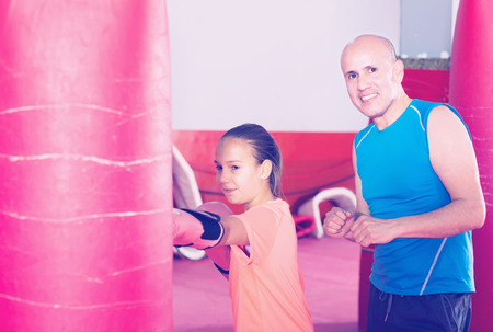 Boxer girl shows her skills to the coach in boxing trainingの写真素材