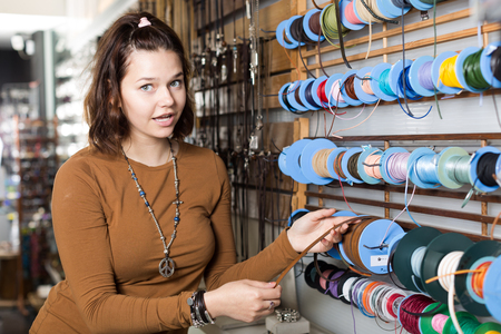 Smiling young woman selling different braids in the marketの写真素材